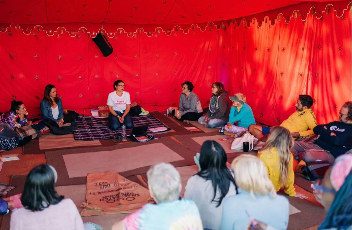 Sophie sitting in a tent with a circle of workshop attendees